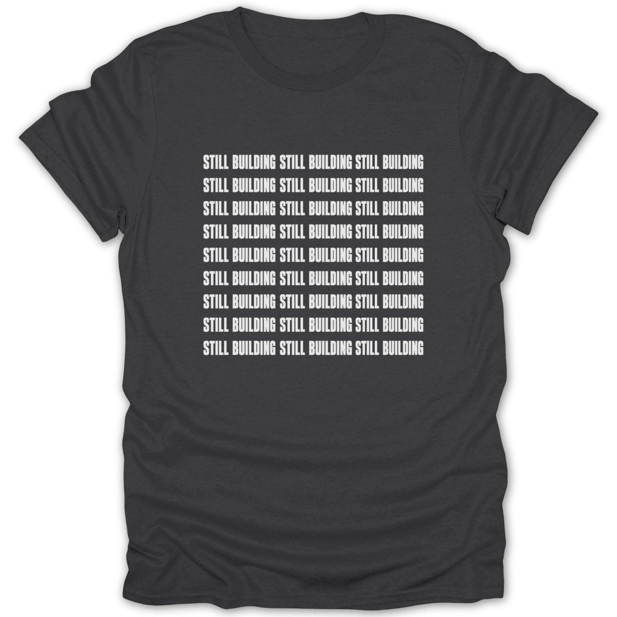 Dark grey t-shirt with white text repeating "Still Building" in rows.