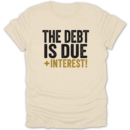 Cream t-shirt with black and gold text reading "THE DEBT IS DUE + INTEREST!"