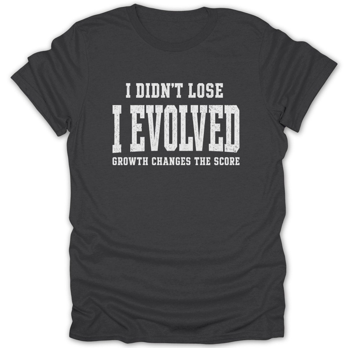 Dark grey t-shirt with white text: "I DIDN'T LOSE I EVOLVED GROWTH CHANGES THE SCORE"